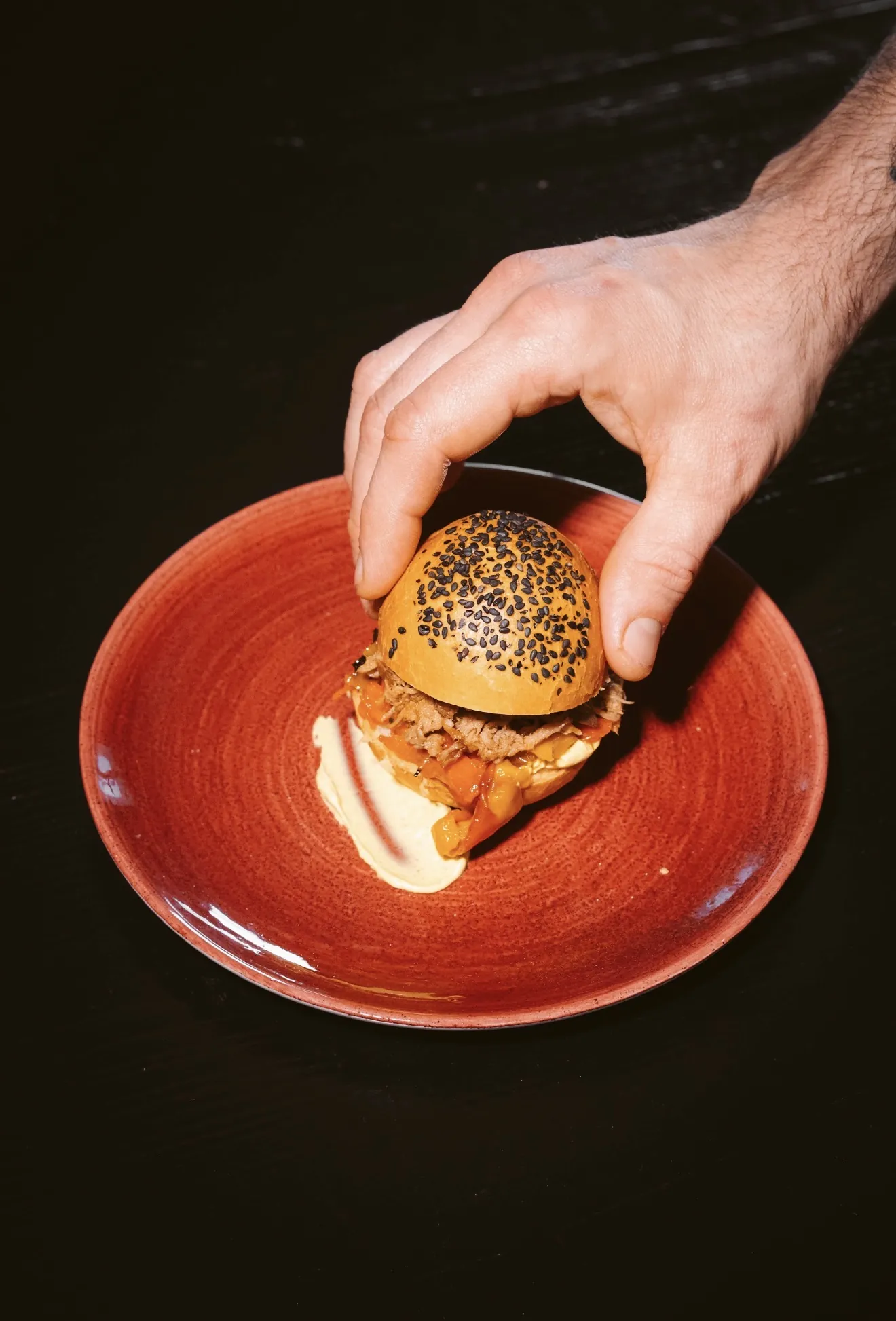 Chef placing garnish on a burger